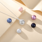 Collier bola Alba argenté posé sur fond crème, entouré de perles décoratives