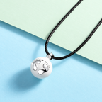 Pendentif bola Éclosion et son cordon noir sur fond pastel