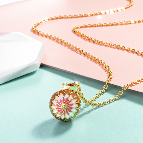 Collier bola Élani posé sur fond rose et vert d’eau