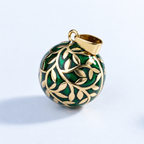 Pendentif bola Eliora doré vu de trois quarts, feuillage en relief sur fond vert