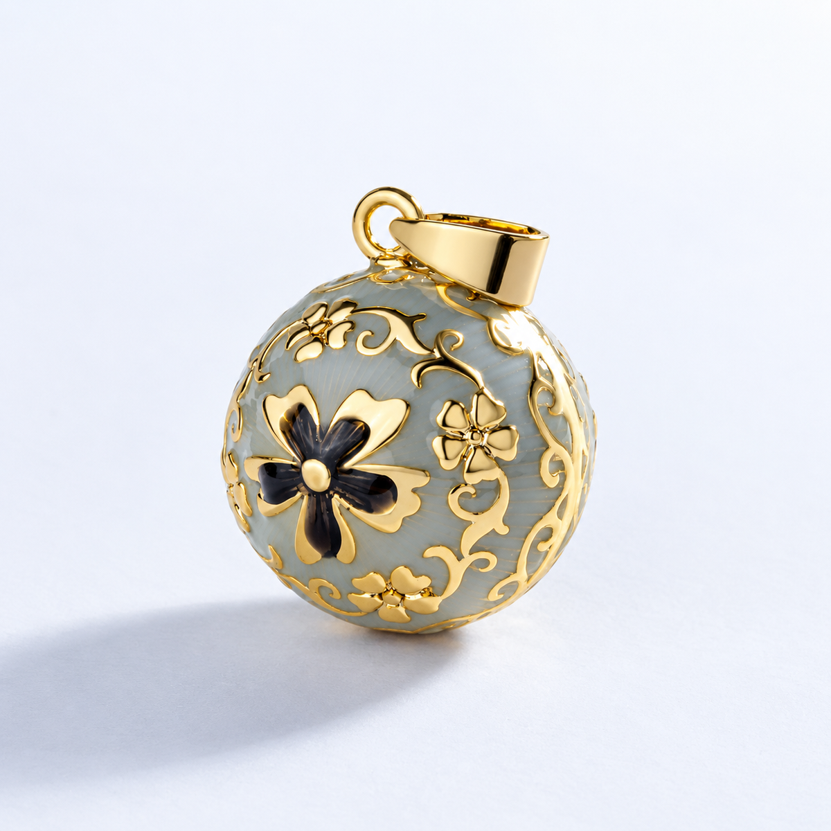 Pendentif bola Élise vu de trois quarts, volutes et fleurs dorées en relief