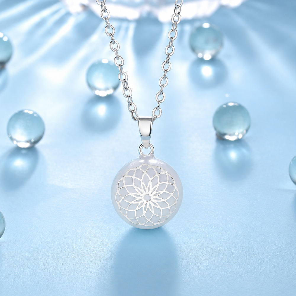 Collier bola Élune blanc et argenté parmi des billes de verre, fond bleu