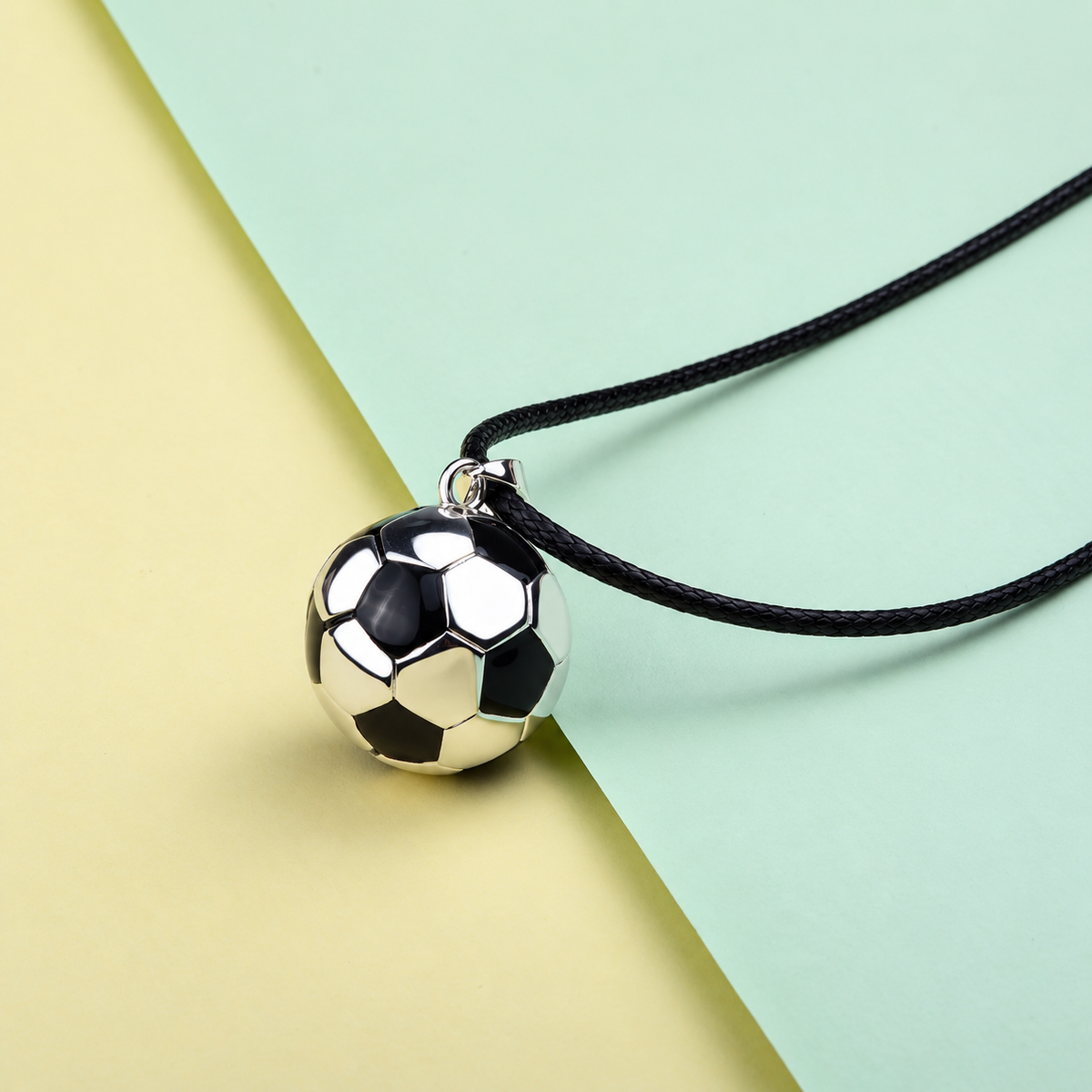 Bola Elyo ballon de foot sur cordon noir, fond jaune et vert d’eau