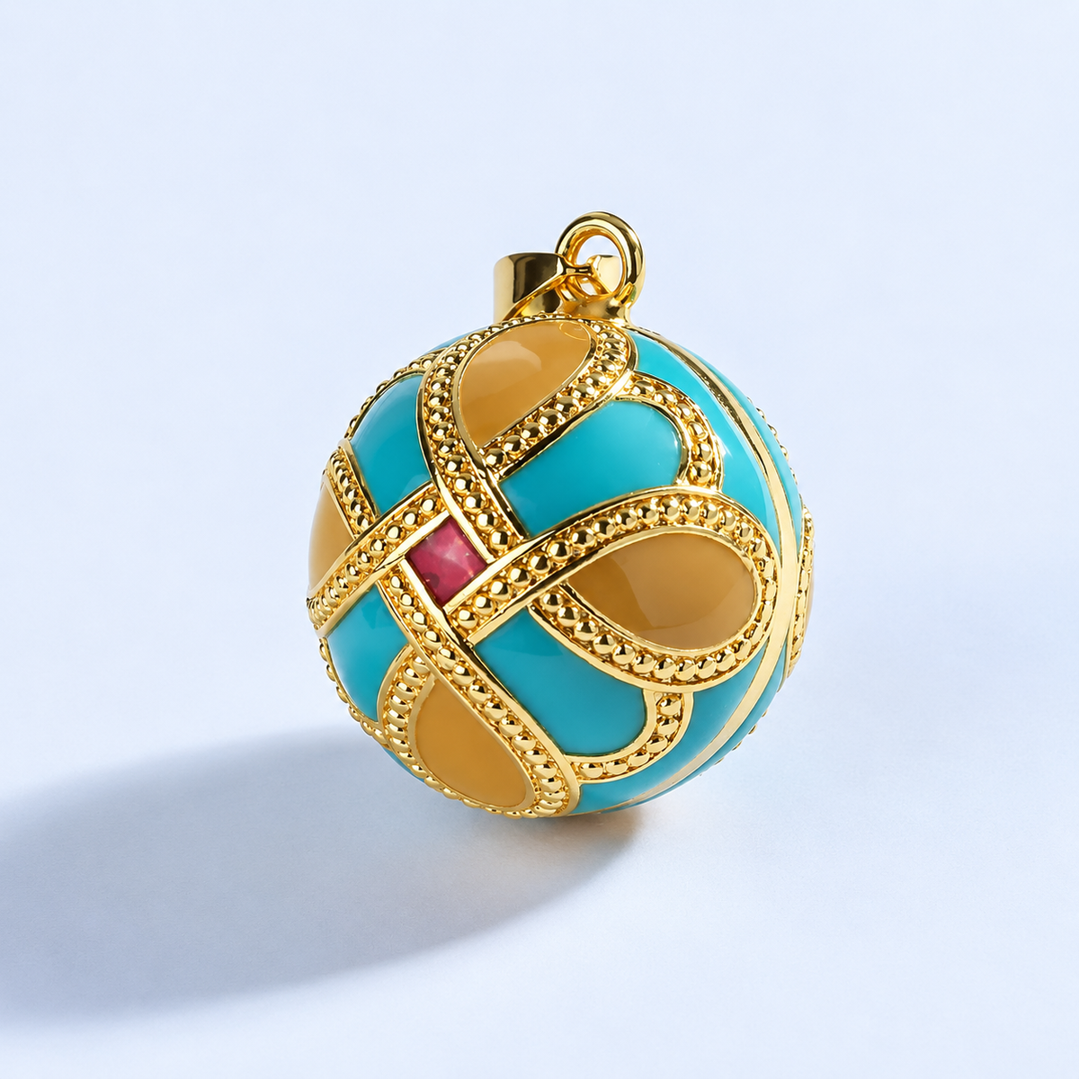 Pendentif bola Éternia vu de trois quarts, losange rouge et perlage doré
