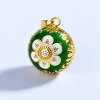 Pendentif bola Léana vu de trois quarts, fleur blanche et bordure dorée