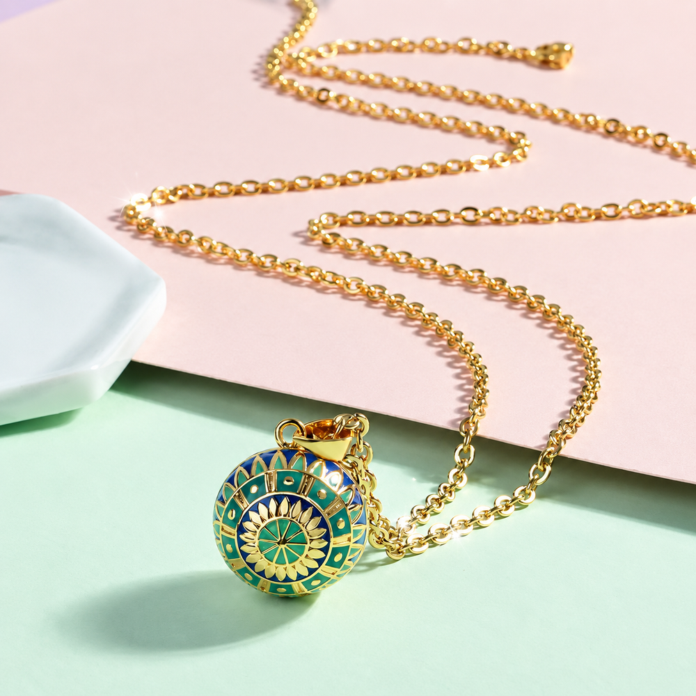 Collier bola Liora posé sur fond rose et vert d’eau