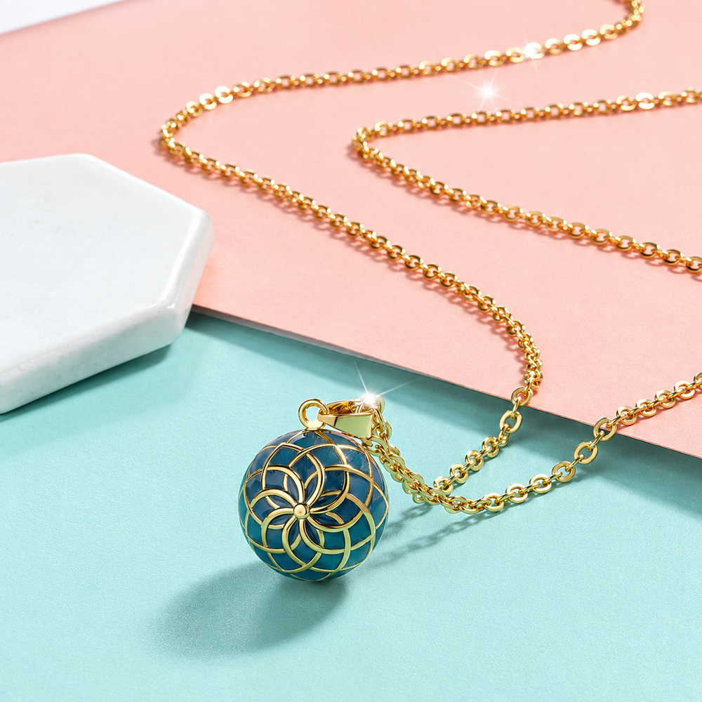 Collier bola Naya posé sur fond rose et vert d’eau