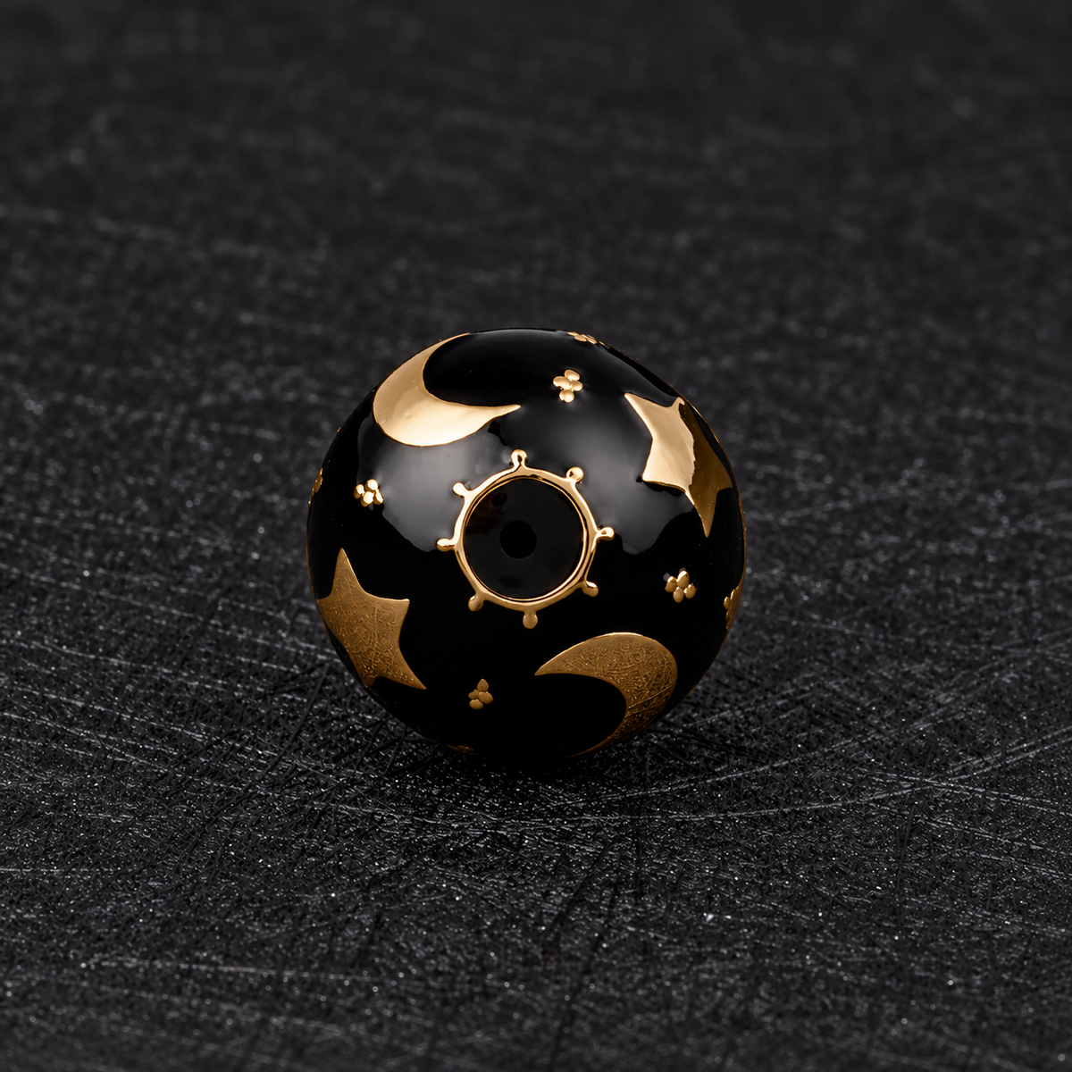 Pendentif bola Noctéa vu de dessous, lunes et étoiles dorées sur fond noir