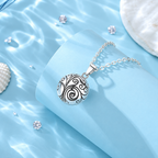 Collier bola Oria posé sur un support bleu, coquillages en décor