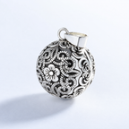 Pendentif bola Sélène vu de trois quarts, motif floral ajouré