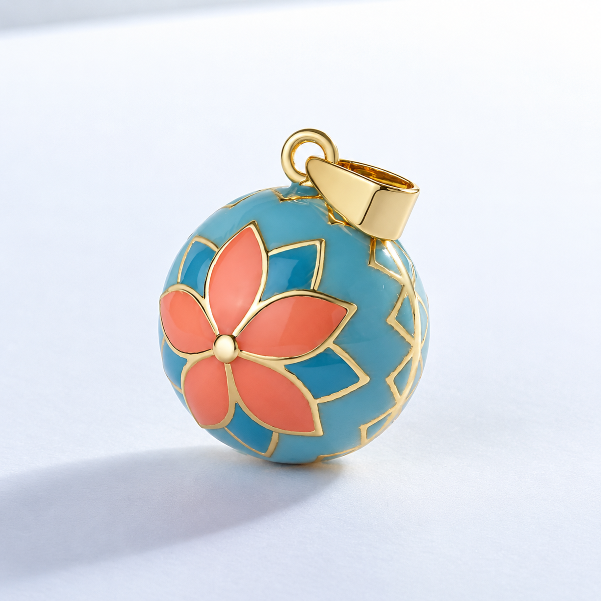 Pendentif bola Sohana vu de trois quarts, pétales corail cernés de doré