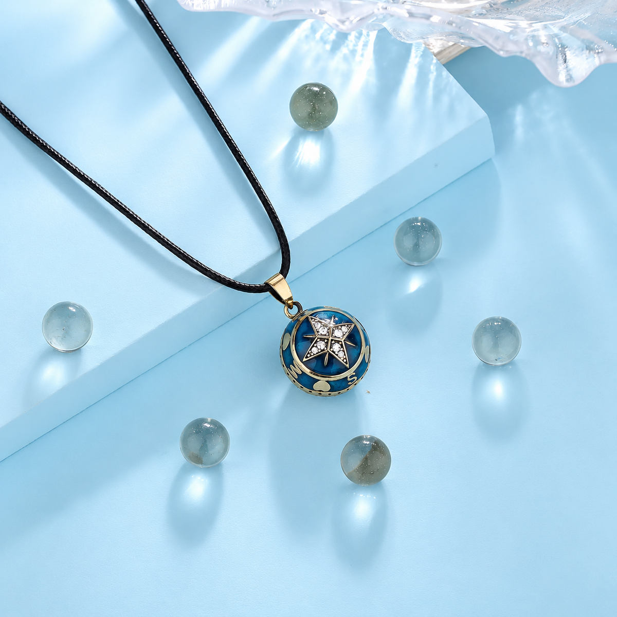 Bola Stella sur son cordon noir, fond bleu clair